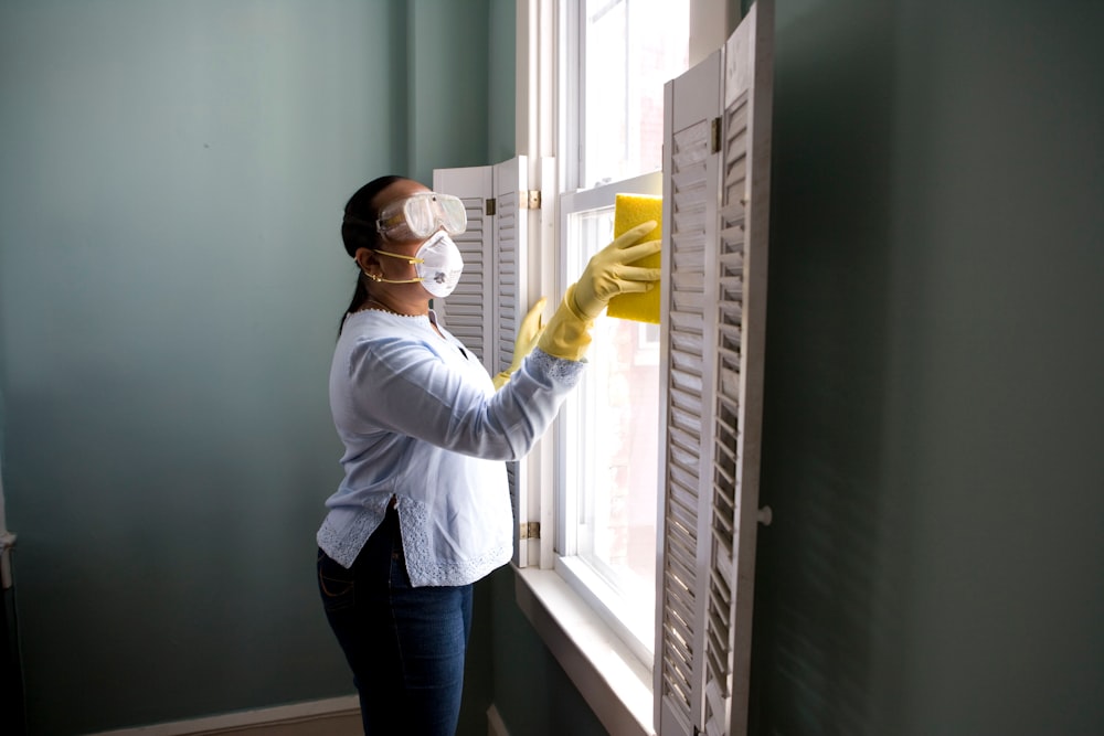 Professional window cleaner wiping a large window to a clear finish in Reno
